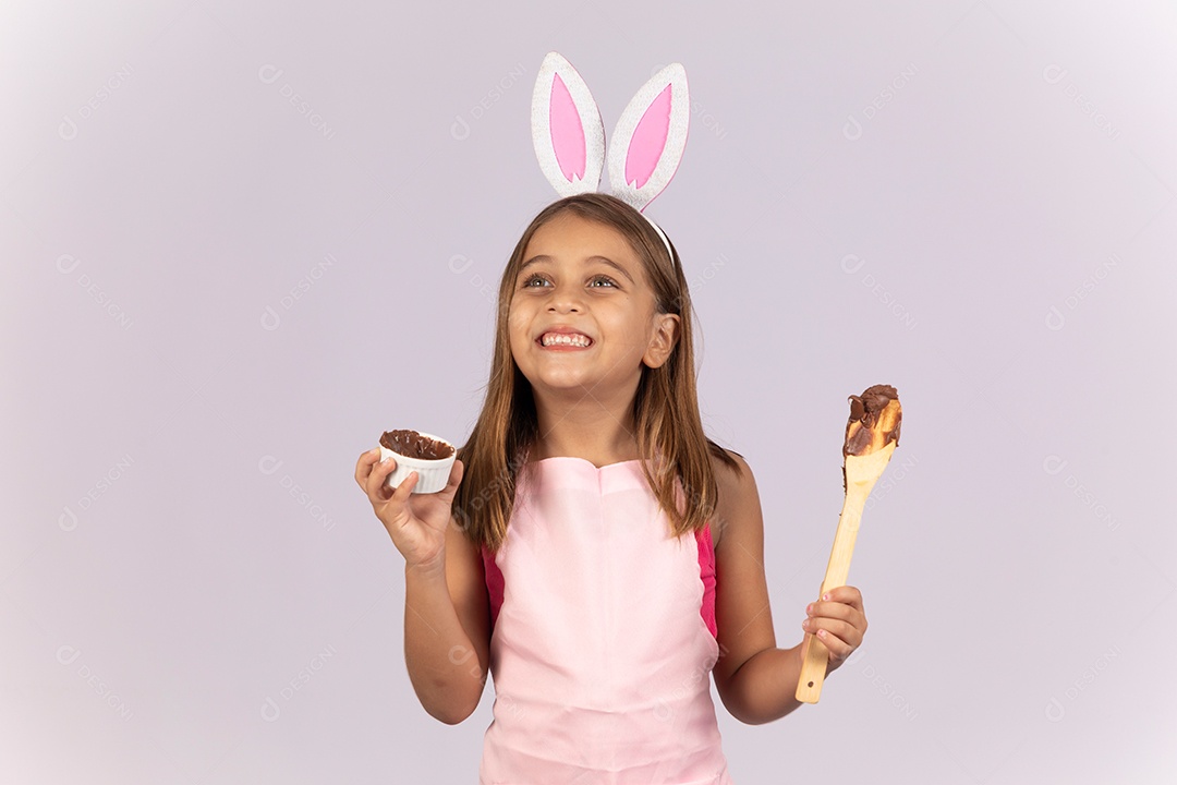 Linda garotinha comendo ovo de chocolate celebrando páscoa