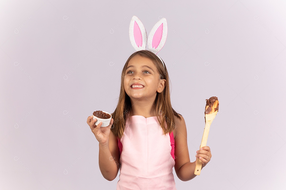 Linda garotinha comendo ovo de chocolate celebrando páscoa