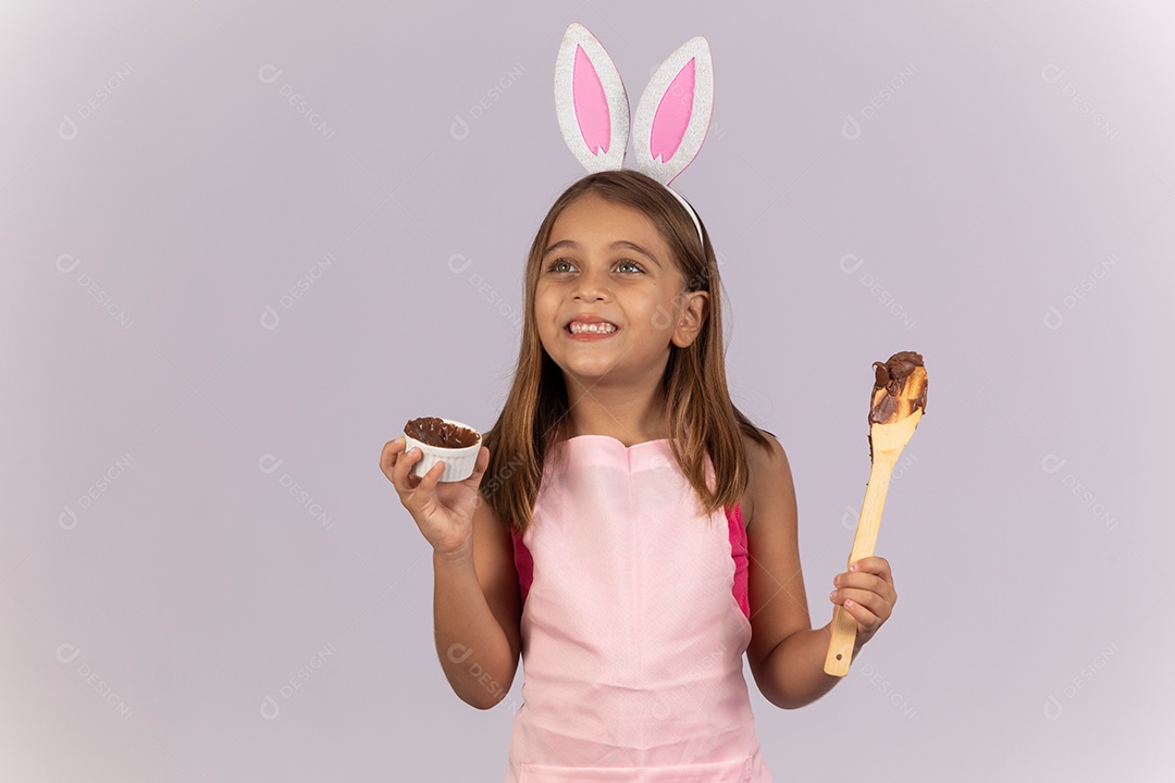 Linda garotinha comendo ovo de chocolate celebrando páscoa