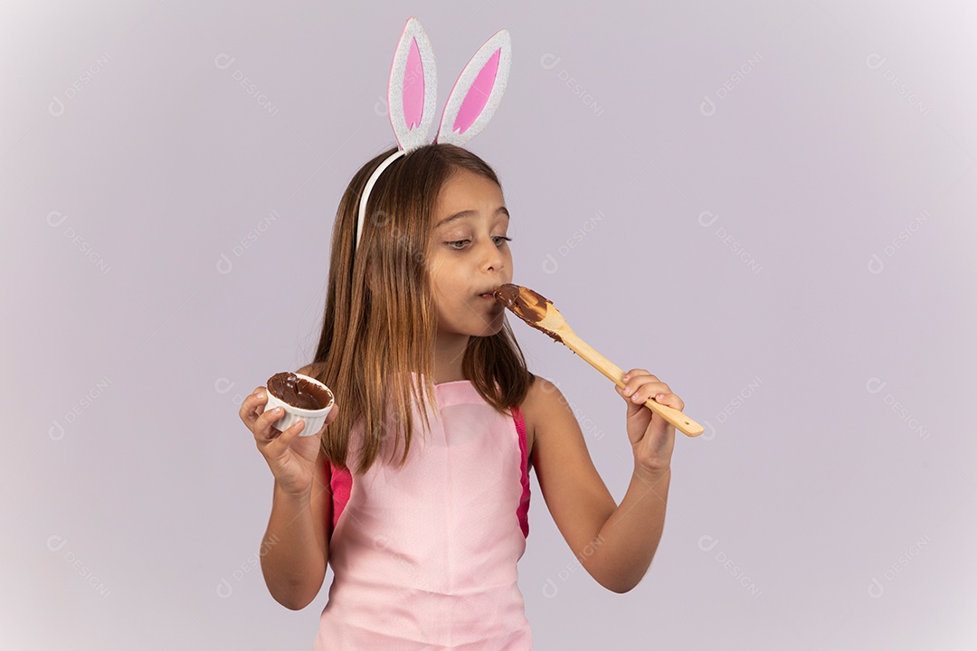 Linda garotinha comendo ovo de chocolate celebrando páscoa