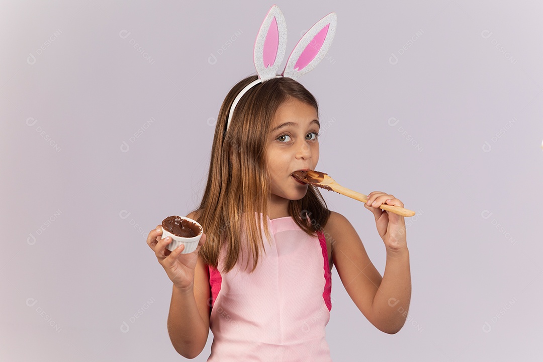 Linda garotinha comendo ovo de chocolate celebrando páscoa