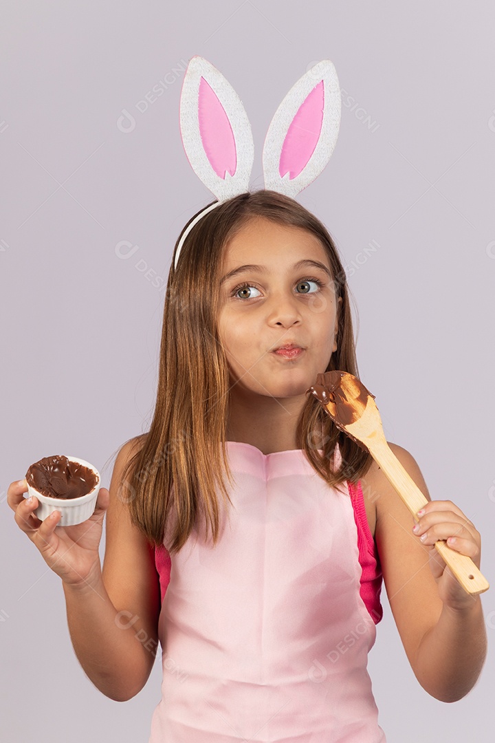 Linda garotinha comendo ovo de chocolate celebrando páscoa