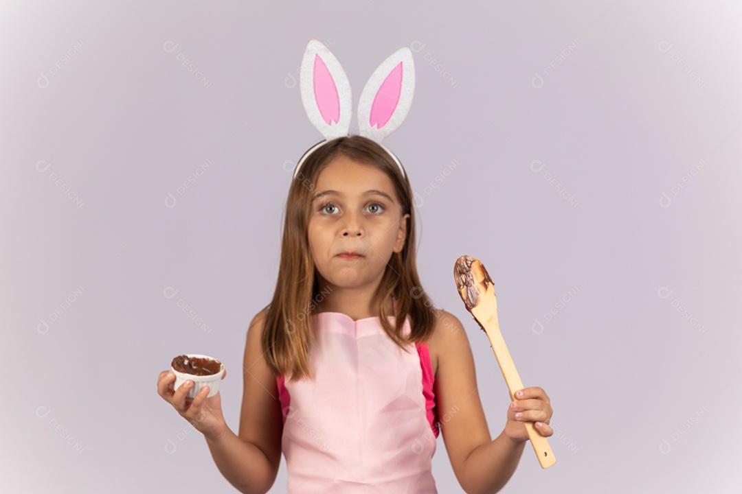 Linda garotinha comendo ovo de chocolate celebrando páscoa