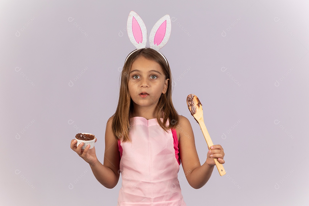 Linda garotinha comendo ovo de chocolate celebrando páscoa