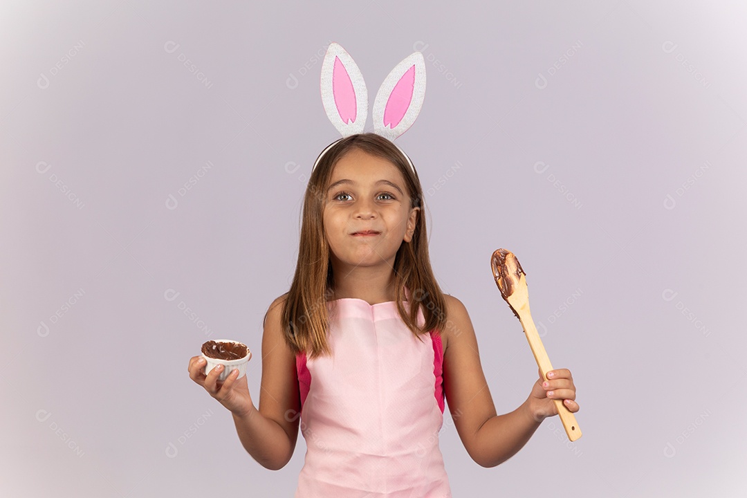 Linda garotinha comendo ovo de chocolate celebrando páscoa