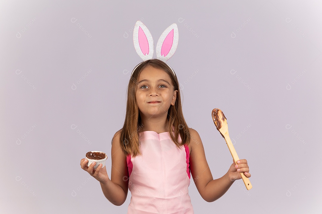 Linda garotinha comendo ovo de chocolate celebrando páscoa