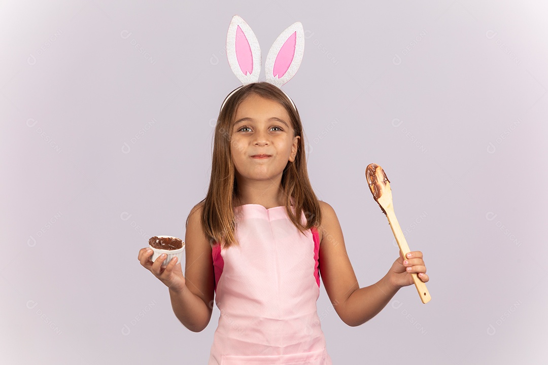 Linda garotinha comendo ovo de chocolate celebrando páscoa