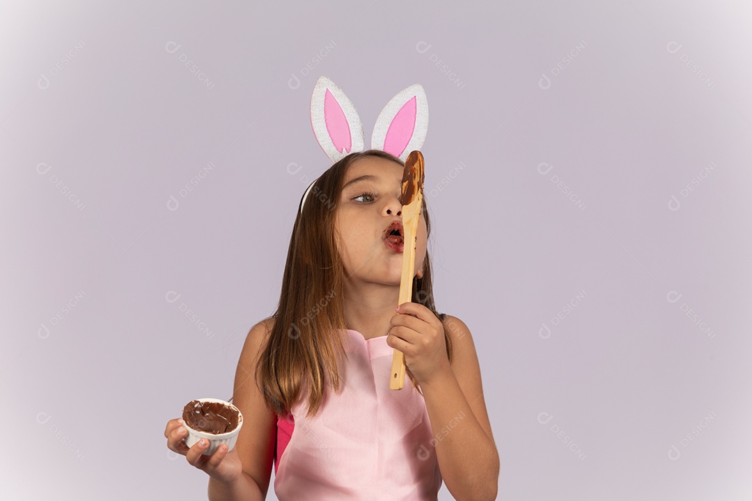 Linda garotinha comendo ovo de chocolate celebrando páscoa