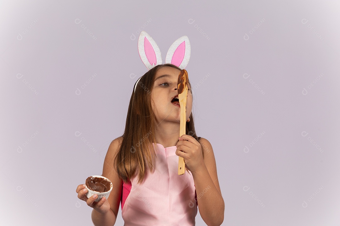 Linda garotinha comendo ovo de chocolate celebrando páscoa