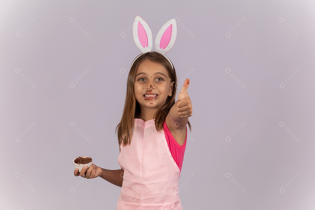 Linda garotinha comendo ovo de chocolate celebrando páscoa
