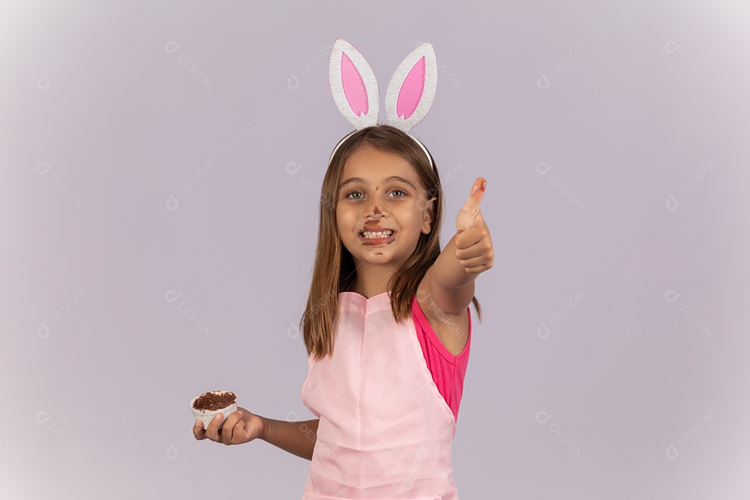 Linda garotinha comendo ovo de chocolate celebrando páscoa