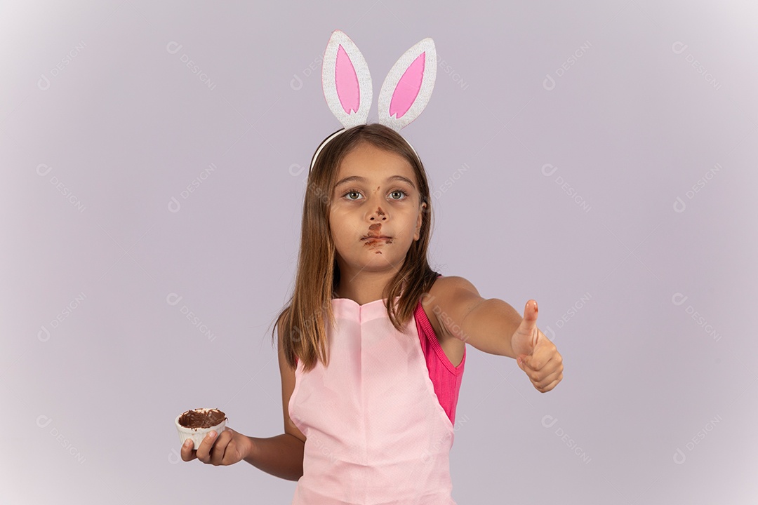 Linda garotinha comendo ovo de chocolate celebrando páscoa