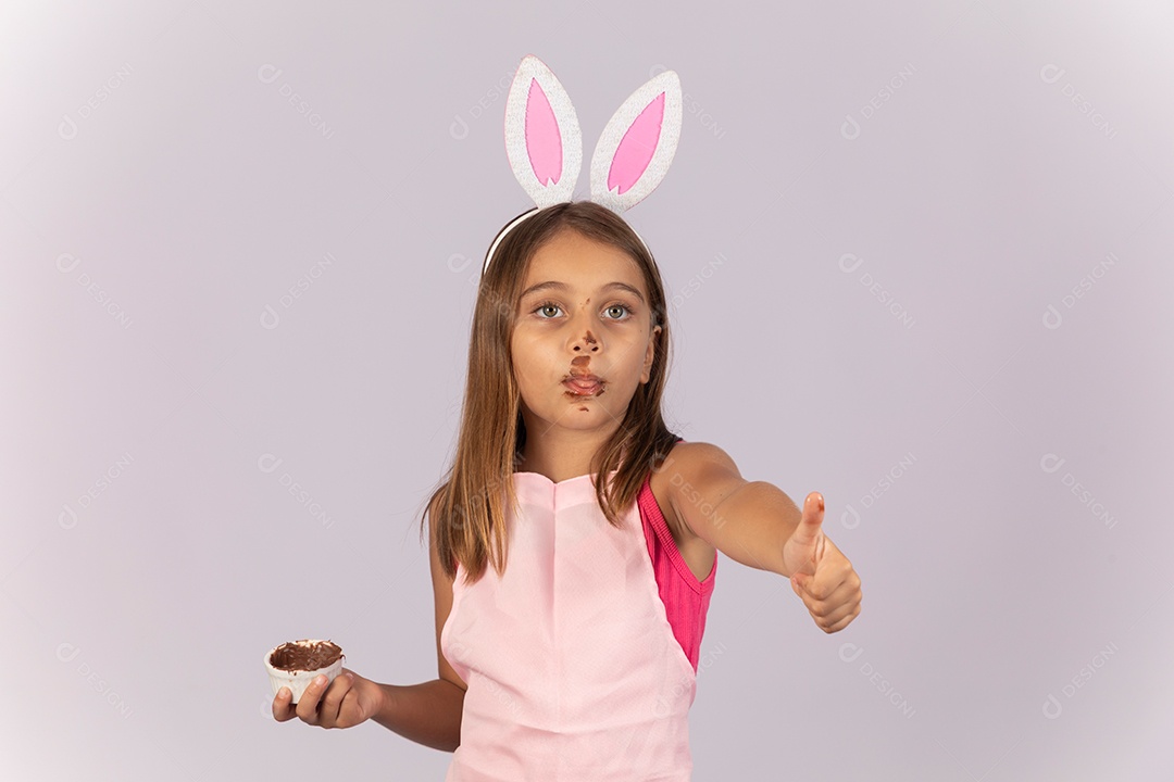Linda garotinha comendo ovo de chocolate celebrando páscoa