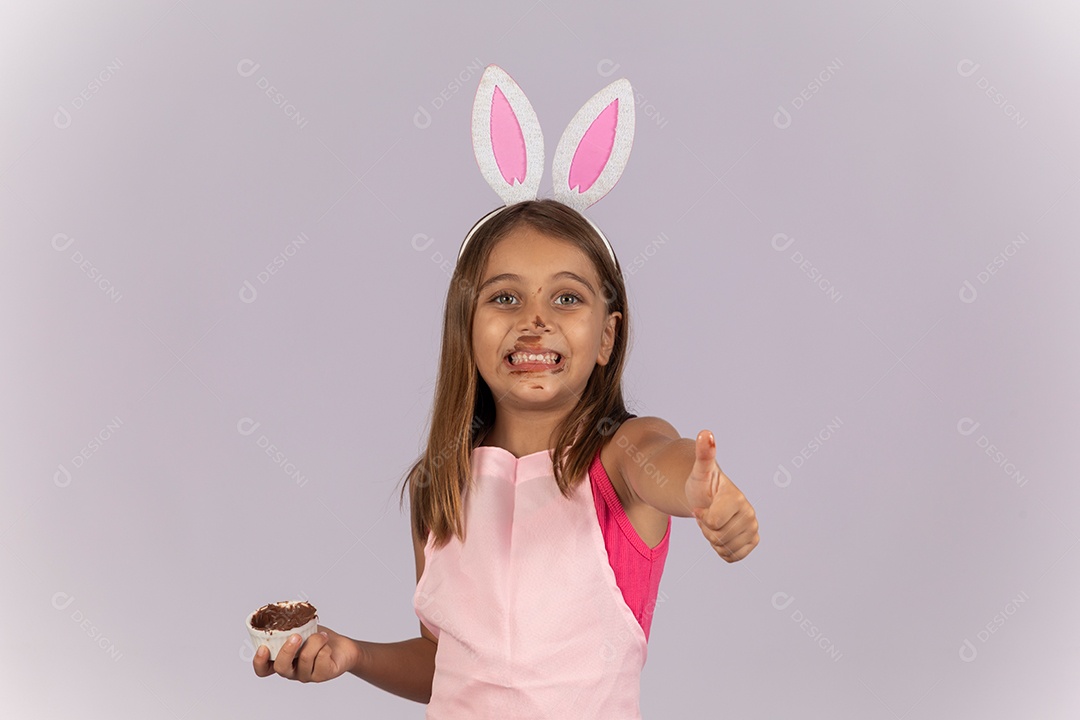 Linda garotinha comendo ovo de chocolate celebrando páscoa