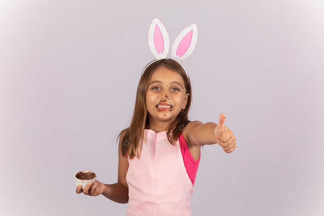 Linda garotinha comendo ovo de chocolate celebrando páscoa