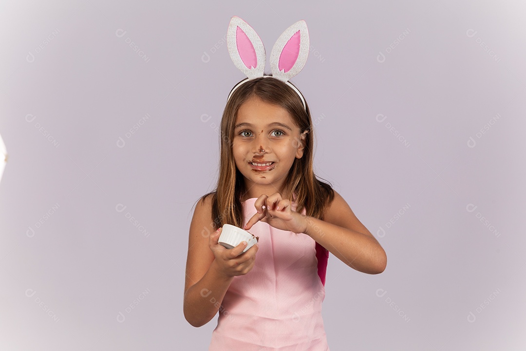 Linda garotinha comendo ovo de chocolate celebrando páscoa