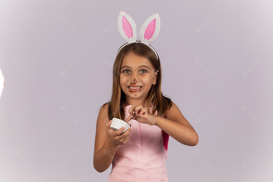 Linda garotinha comendo ovo de chocolate celebrando páscoa