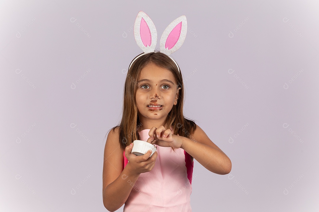 Linda garotinha comendo ovo de chocolate celebrando páscoa