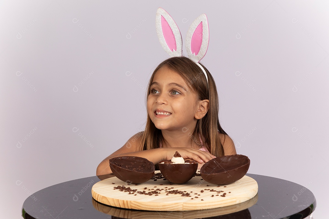 Linda garotinha comendo ovo de chocolate celebrando páscoa