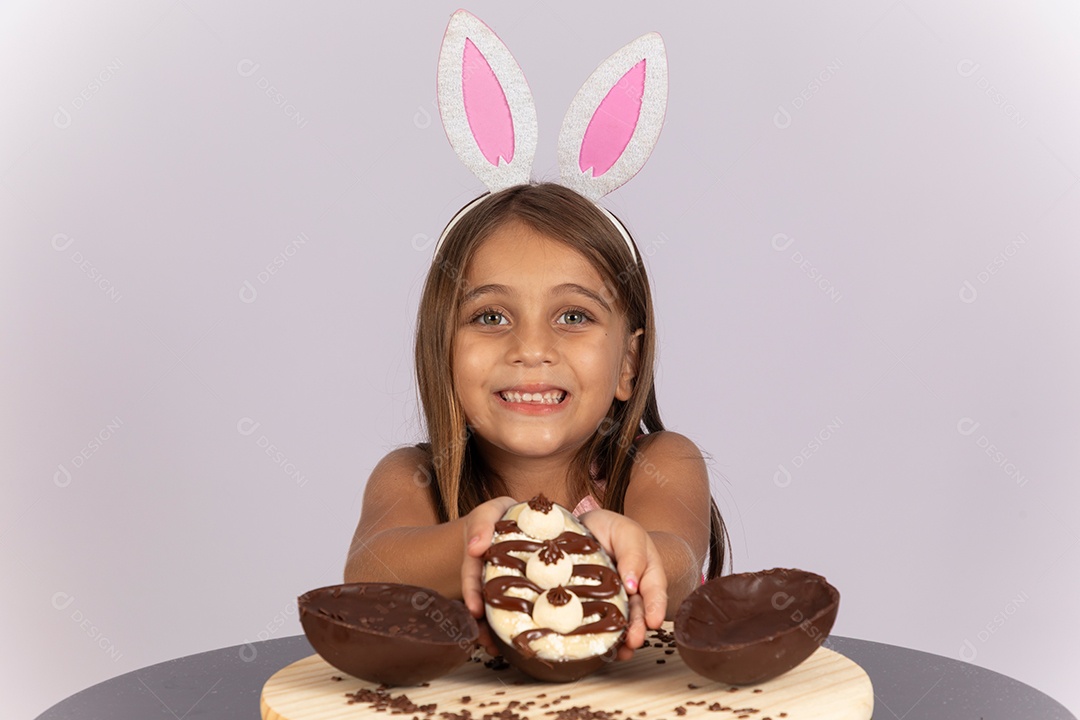 Linda garotinha comendo ovo de chocolate celebrando páscoa