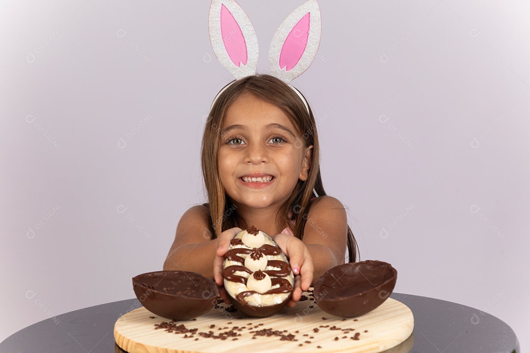 Linda garotinha comendo ovo de chocolate celebrando páscoa