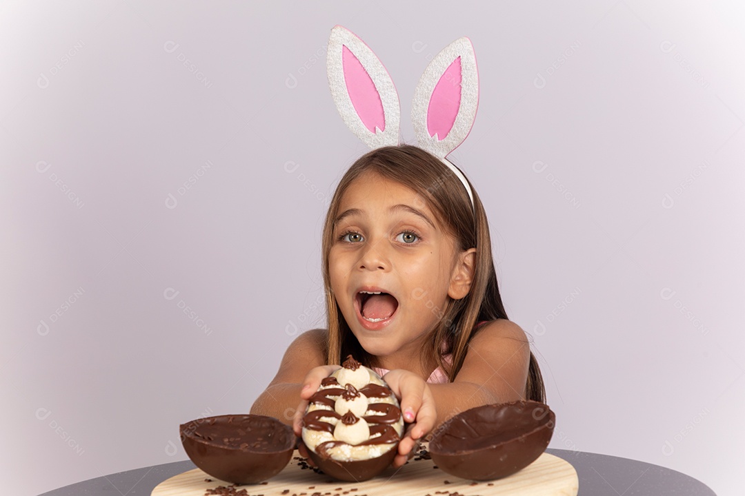 Linda garotinha comendo ovo de chocolate celebrando páscoa
