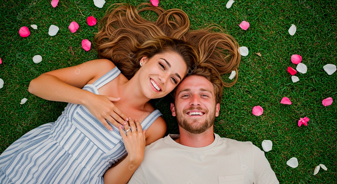Lindo casal felizes deitados sobre uma grama em um parque