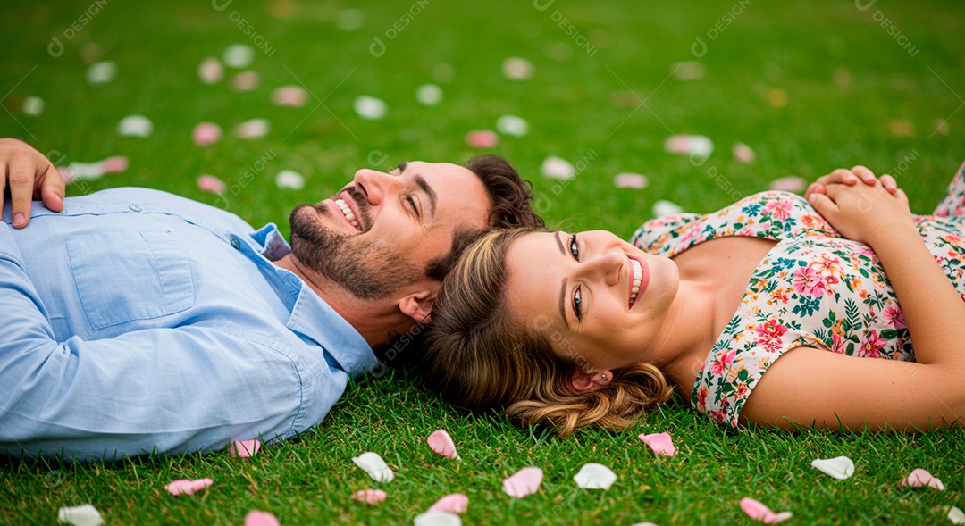 Lindo casal felizes deitados em uma grama em um parque