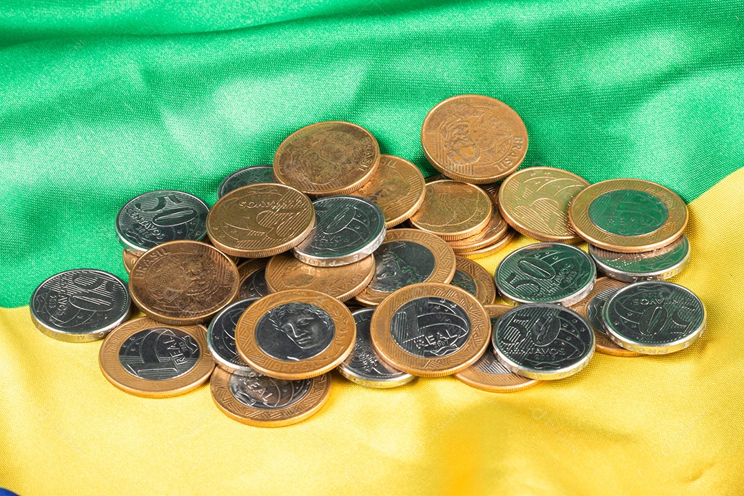 Moedas brasileiras exibidas na bandeira nacional nas cores verde e amarela