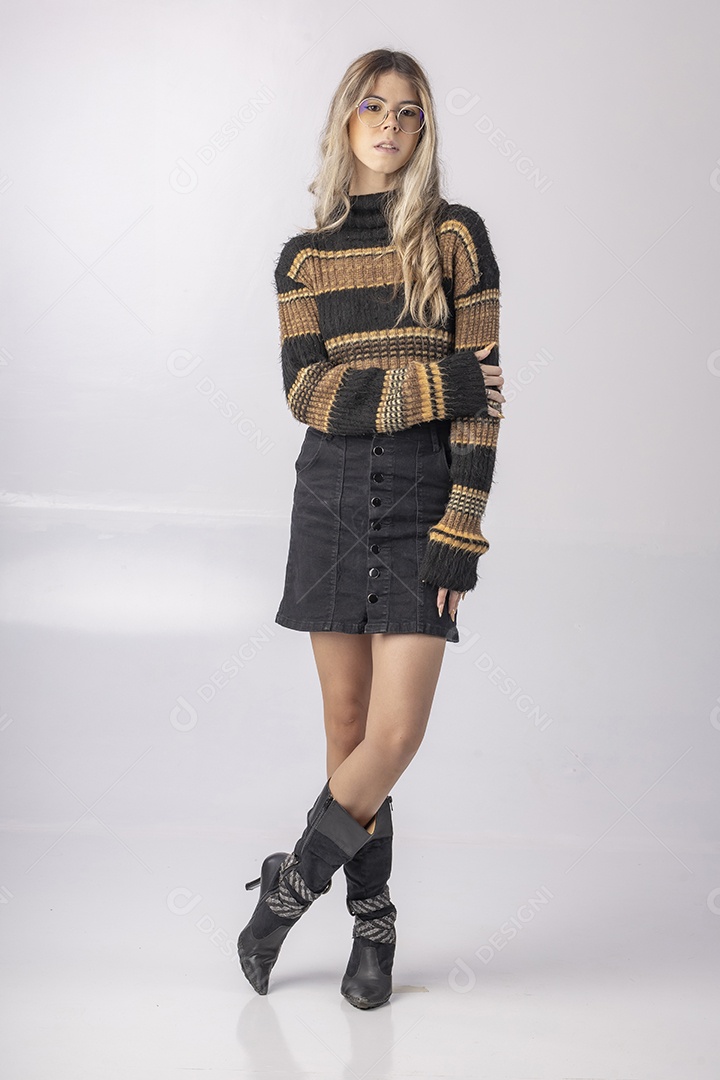 Jovem vestindo blusa e saia apontando para o lado em foto de estúdio