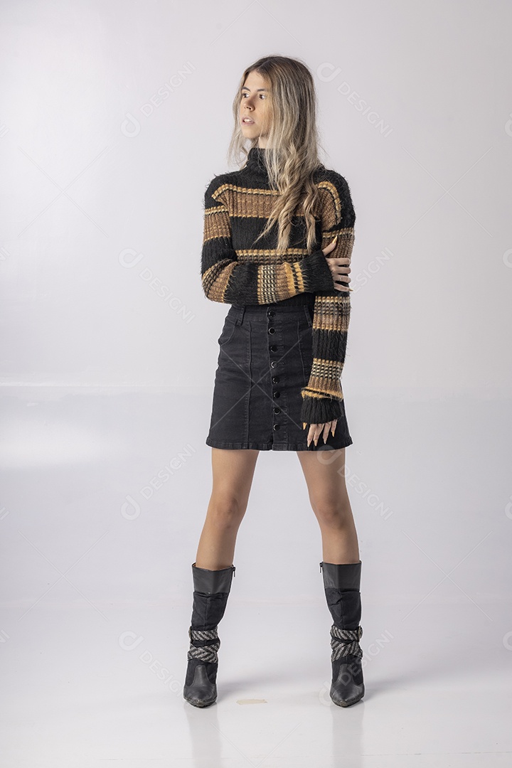 Jovem vestindo blusa e saia apontando para o lado em foto de estúdio