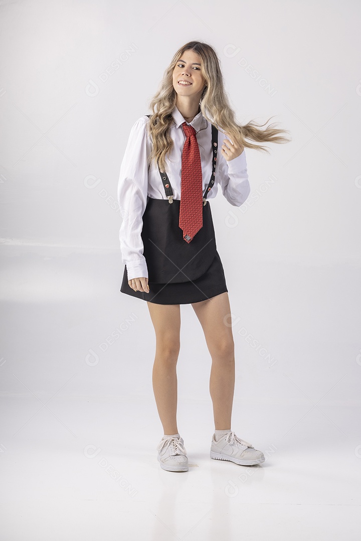 Jovem estudante com roupa escolar e livros nas mãos