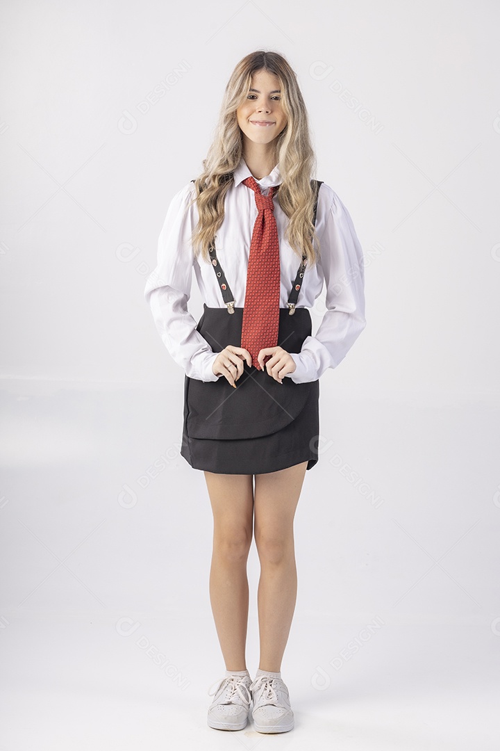 Jovem estudante com roupa escolar e livros nas mãos