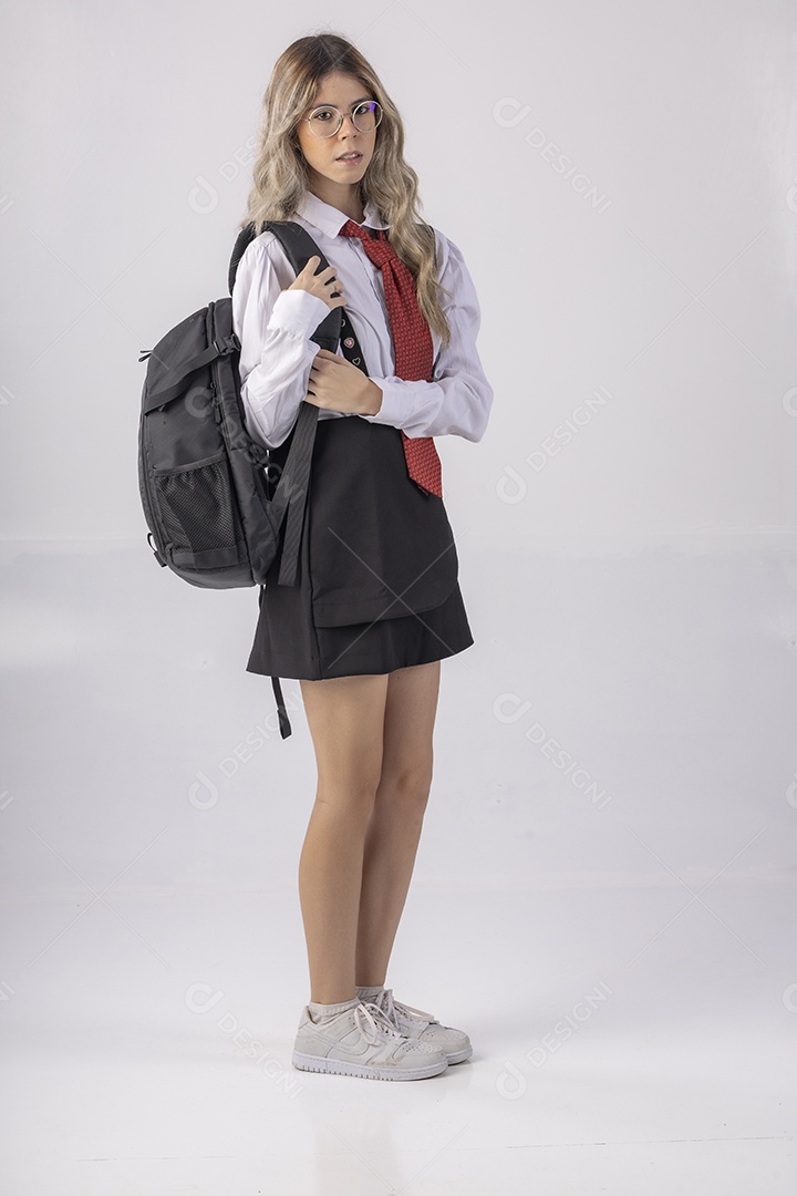 Jovem estudante com roupa escolar e livros nas mãos