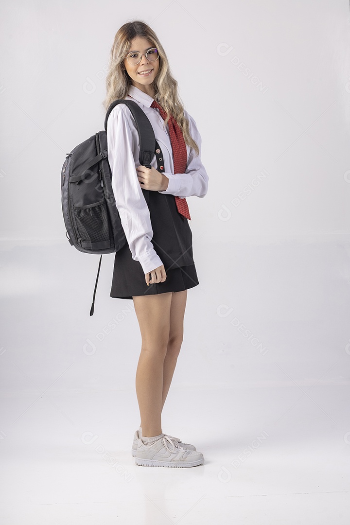 Jovem estudante com roupa escolar e livros nas mãos