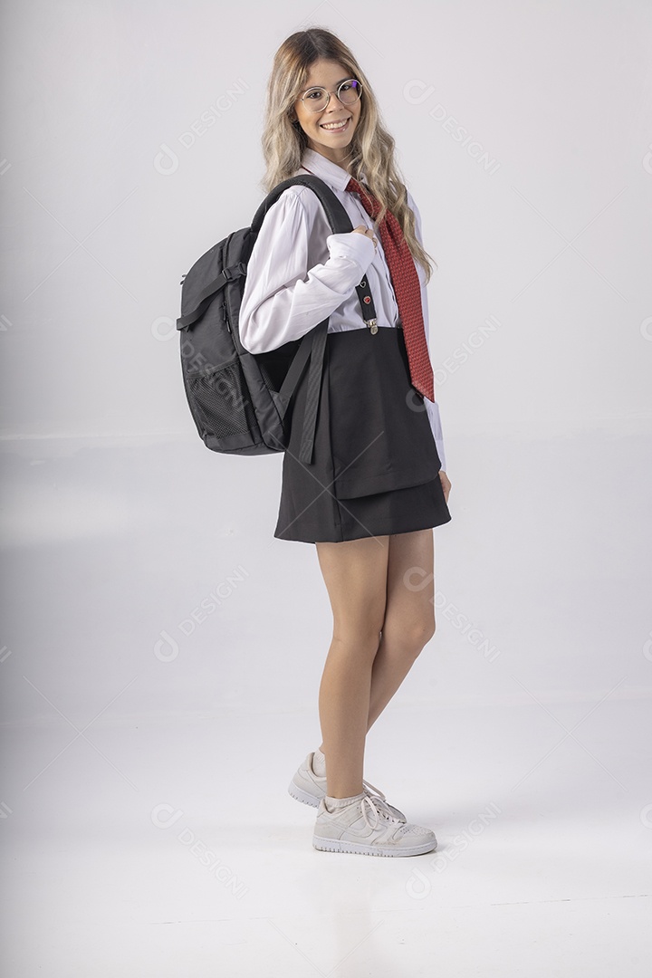 Jovem estudante com roupa escolar e livros nas mãos