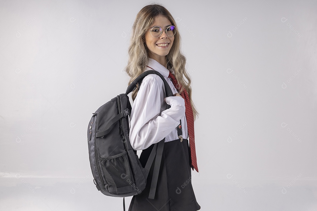 Jovem estudante com roupa escolar e livros nas mãos