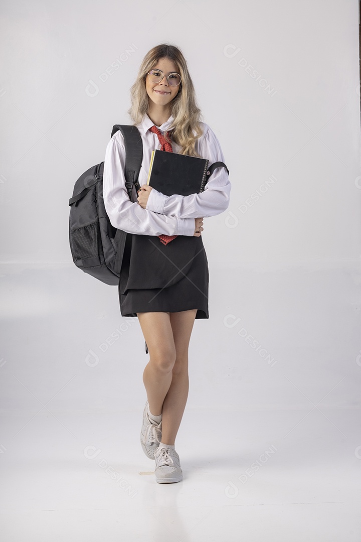 Jovem estudante com roupa escolar e livros nas mãos