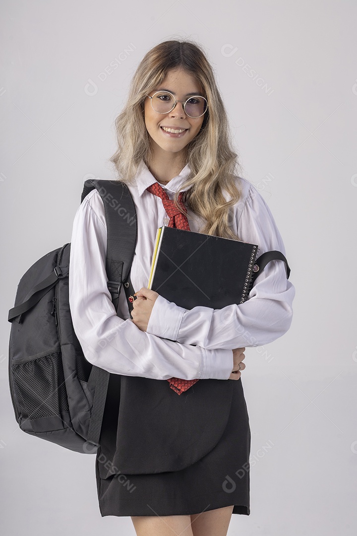 Jovem estudante com roupa escolar e livros nas mãos