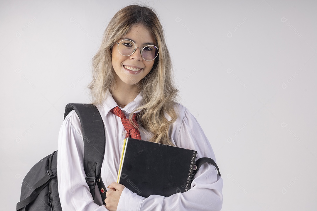 Jovem estudante com roupa escolar e livros nas mãos
