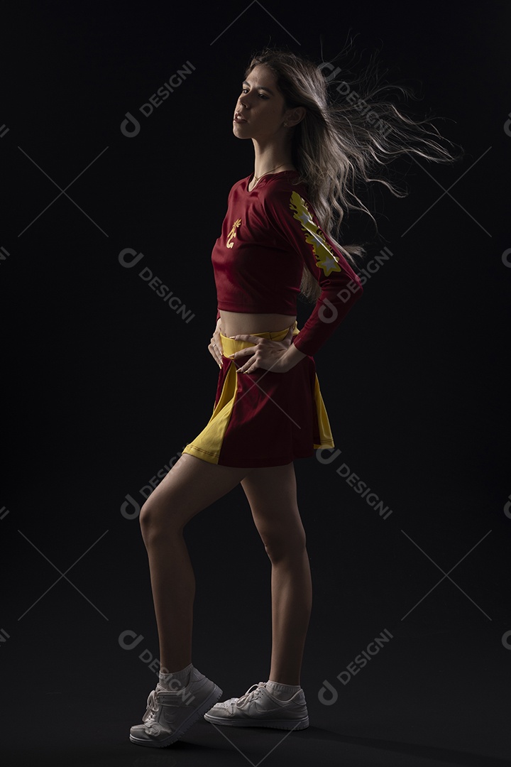 Jovem loira usando um vestido luxuoso em um fundo preto