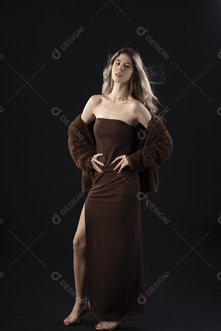 Jovem loira usando um vestido luxuoso em um fundo preto