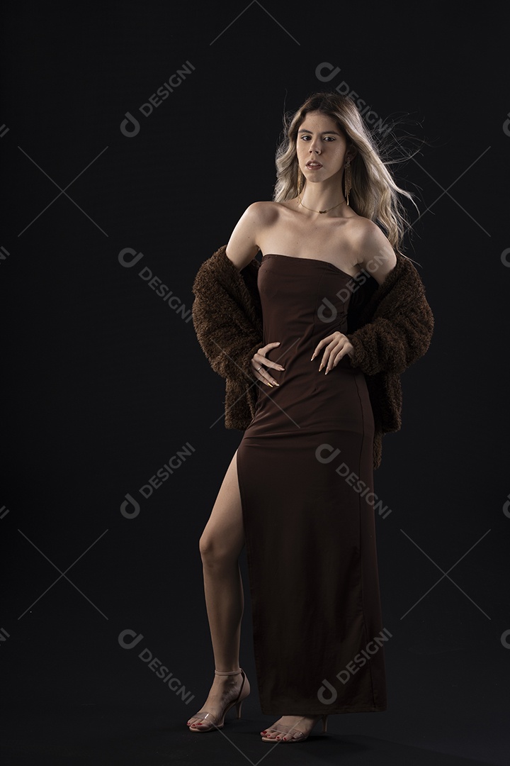 Jovem loira usando um vestido luxuoso em um fundo preto