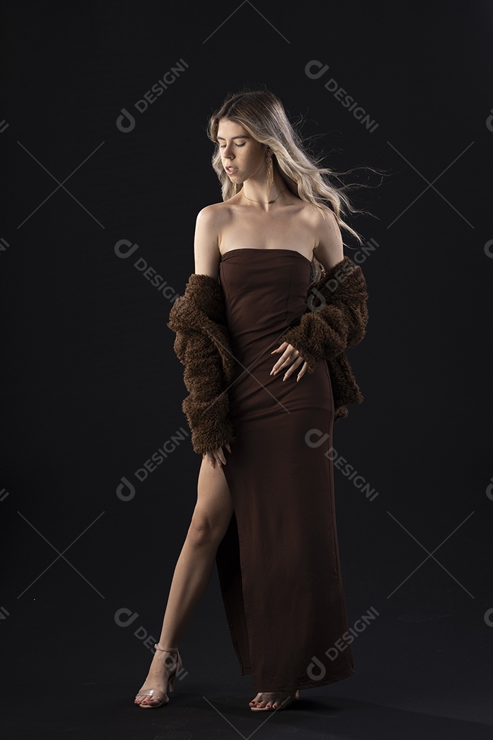 Jovem loira usando um vestido luxuoso em um fundo preto