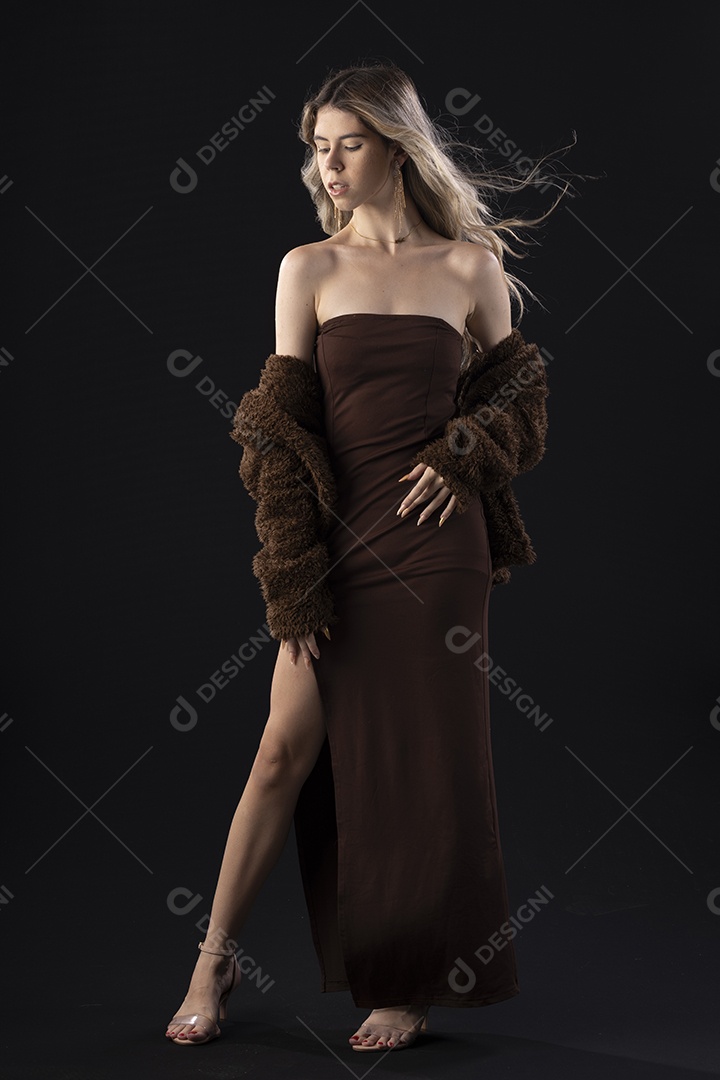 Jovem loira usando um vestido luxuoso em um fundo preto