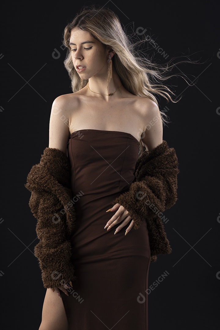 Jovem loira usando um vestido luxuoso em um fundo preto