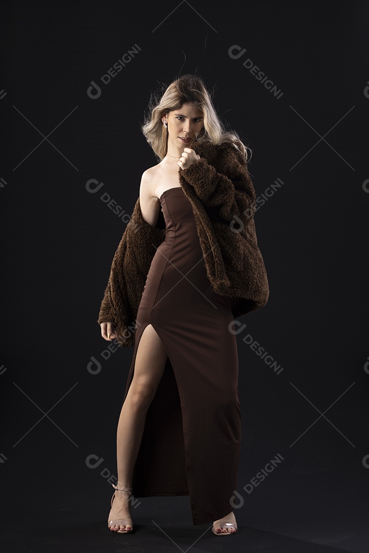 Jovem loira usando um vestido luxuoso em um fundo preto