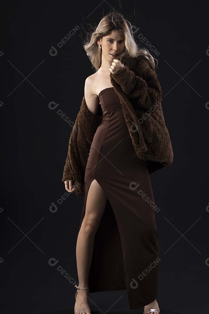 Jovem loira usando um vestido luxuoso em um fundo preto