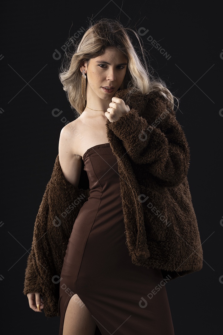 Jovem loira usando um vestido luxuoso em um fundo preto