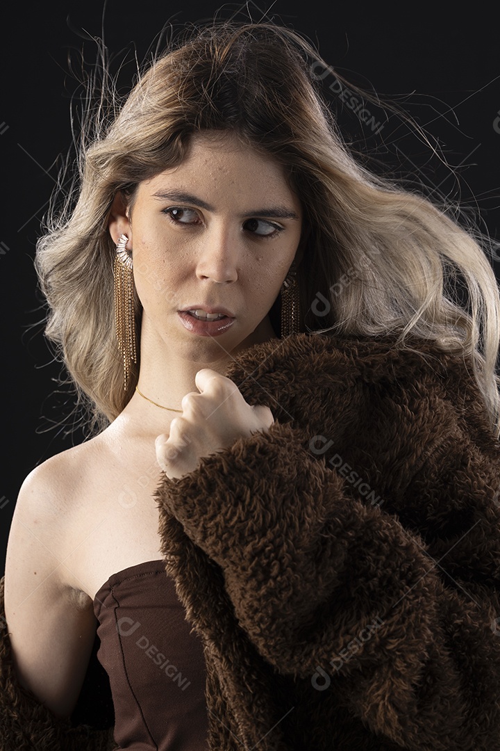 Jovem loira usando um vestido luxuoso em um fundo preto